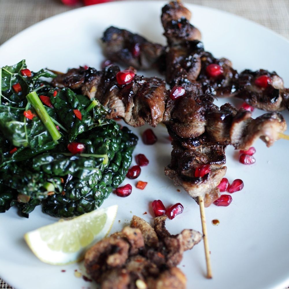 grilled spiced duck skewers w/ kale stir fry, pomegranates and crispy duck skin