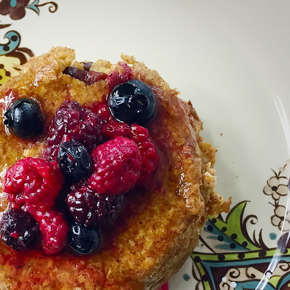Cranberry cinnamon baked oatmeal topped with warm berries and honey