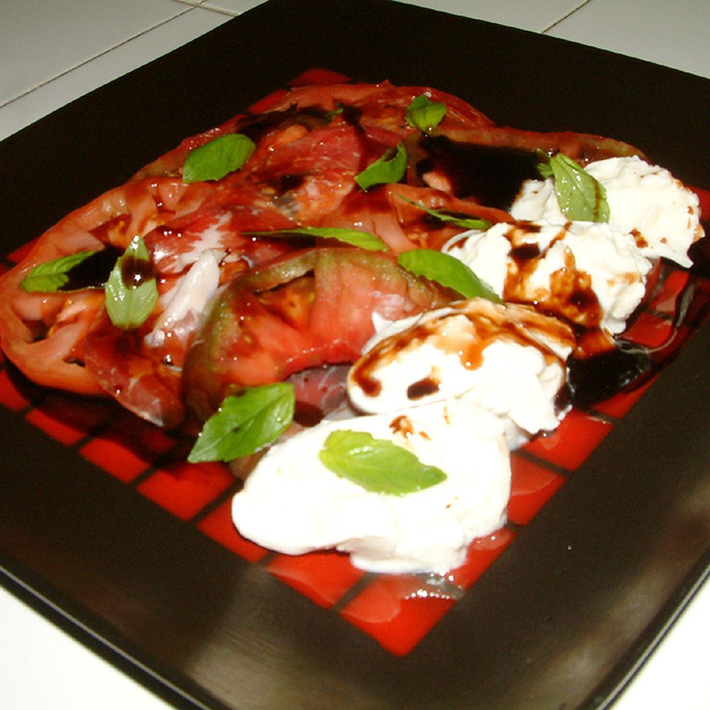 Locally grown heirloom tomato salad with fresh burrata cheese and coppa.